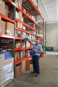 hvac technician standing in warehouse holding a humidifier pad