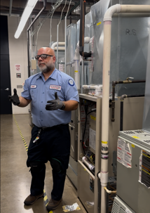 service technician standing in front of a furnace talking