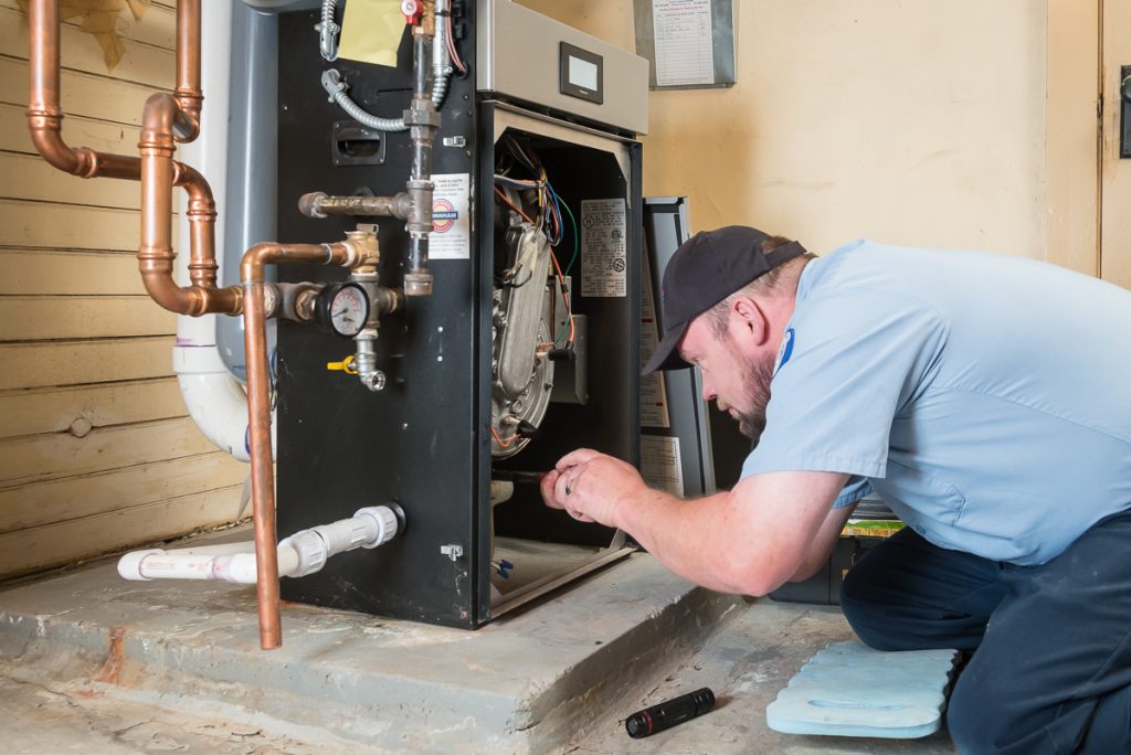 Technician checking on a boiler unit