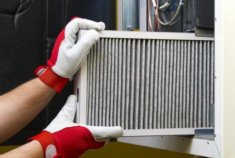 technician replacing furnace air filter