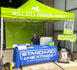 technician sitting at booth at farmers market