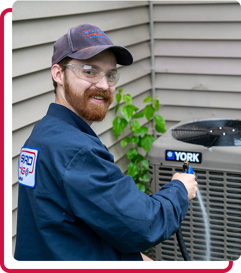technician smiling while working on an AC unit