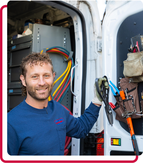 technician posed with pliers by company truck