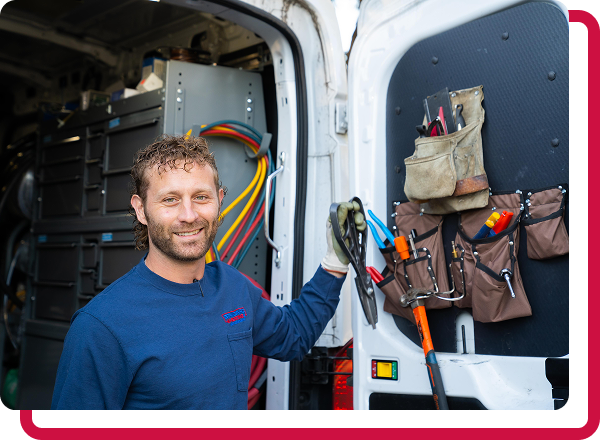 technician posed with pliers by company truck