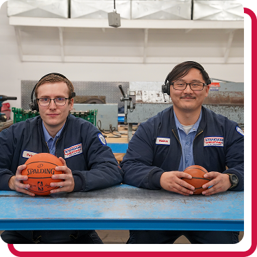 Men holding basketballs in Standard Heating & Air Conditioning uniforms